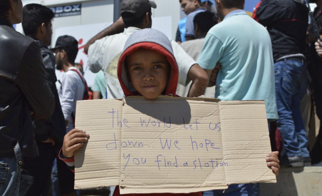 A kid shows a cardboard with “The world let us down...we hope you find a s[o]lution” written on it, during a peaceful manifestation at Idomeni, when a Europe Union delegation visited the makeshift camp