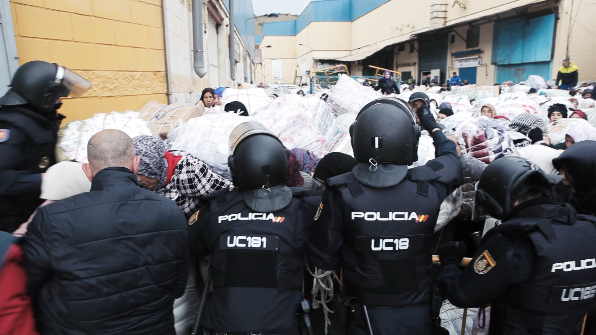 Police hold the surging crowd of women back at the border in Ceuta