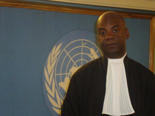 Charles Adeogun-Phillips stands in front of UN sign