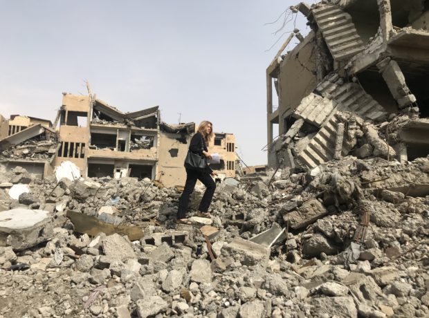Anna Neistat of Human Rights Watch walks over buildings that have been reduced to rubble
