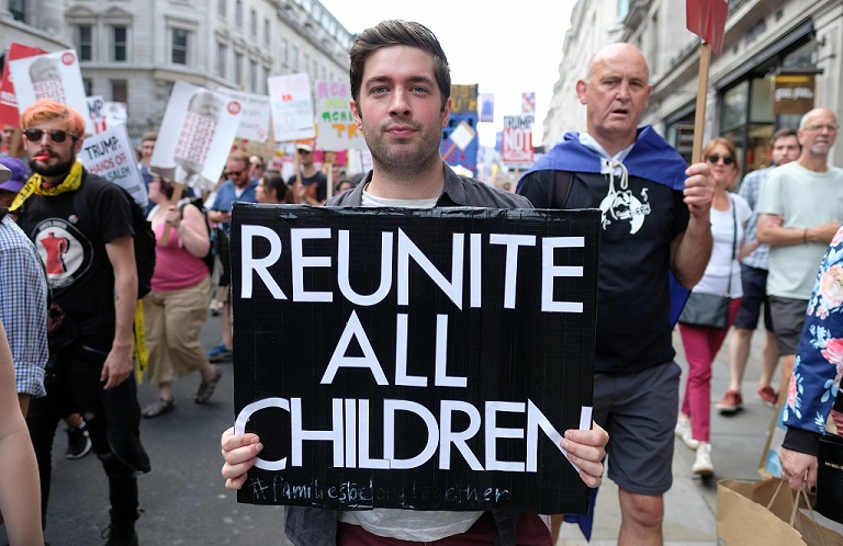 Reunite children placard protesting the US separating migrant families