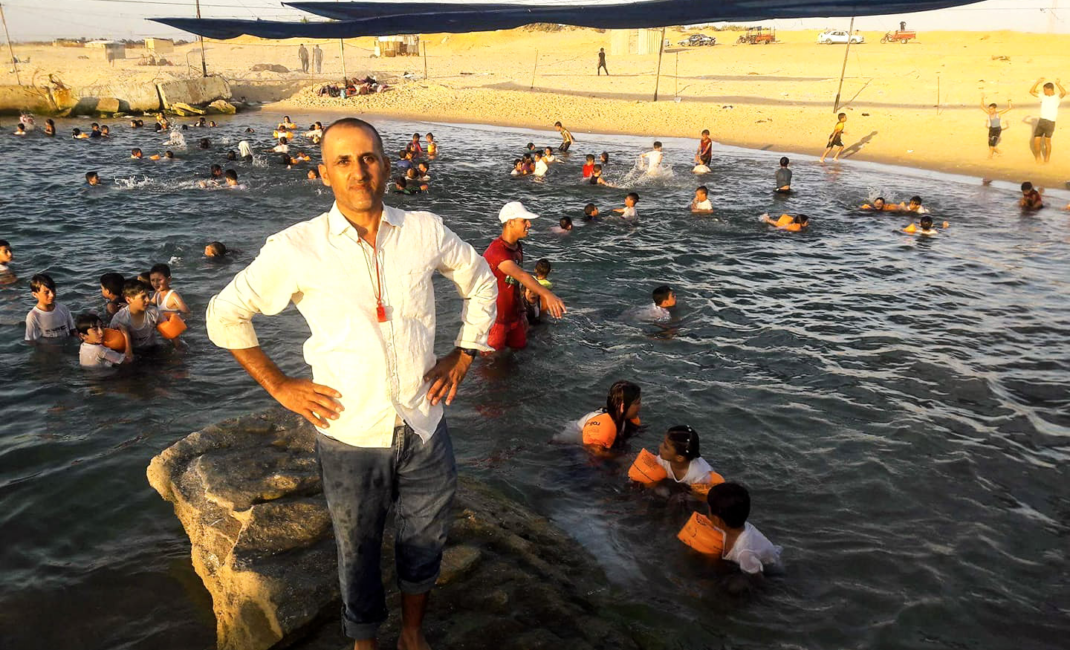 Instructor Amjad Tantish at the swimming pool he constructed out of rubble.