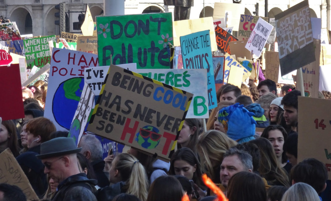Children wave environmental placards such as "Being cool has never been so hot"