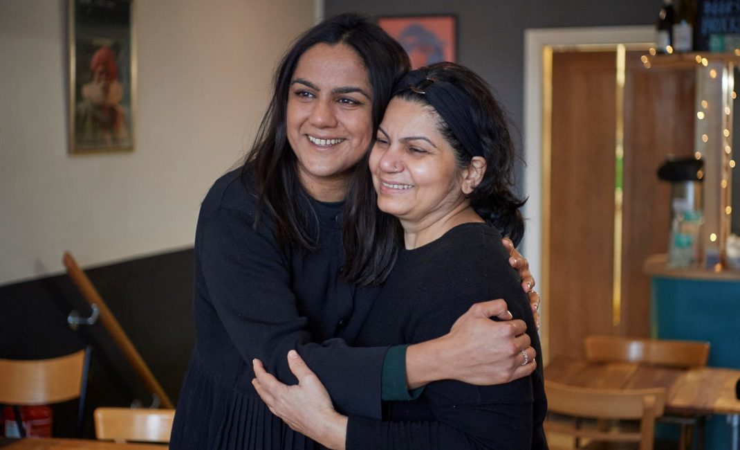Saima Thompson and her mum smile and hug each other