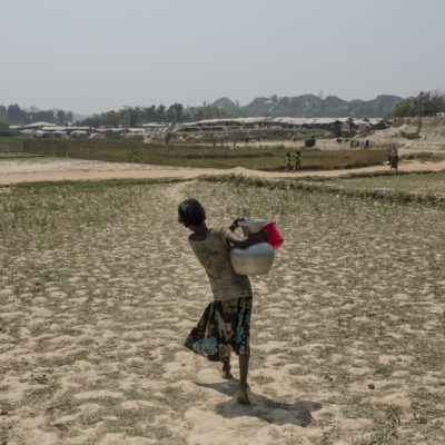 A Rohingya girl carries water to her camp