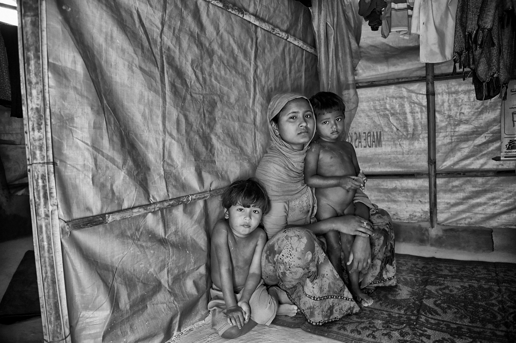 Farjina with her two sons, in their makeshift hut in the Balukhali Refugee Camp by Francesc Galban
