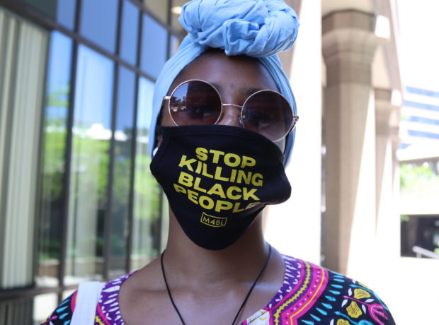 Black woman wearing a 'Stop Killing Black People' mask. Demonstrates that even withing a global pandemic, black people are fighting for their lives everyday