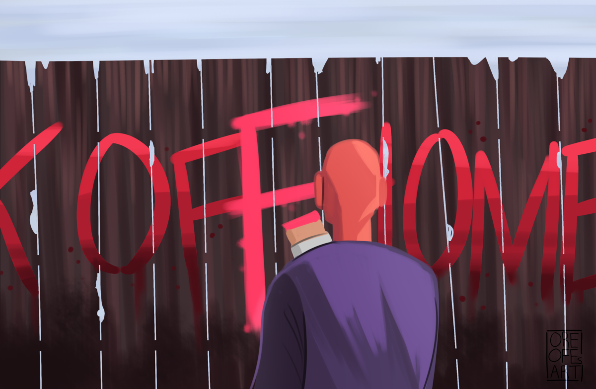 A man stands with his back to us, painting a red F over graffiti on a fence