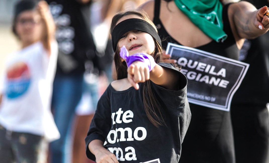A young girl dancing during a 'Rapist in your Path' protest