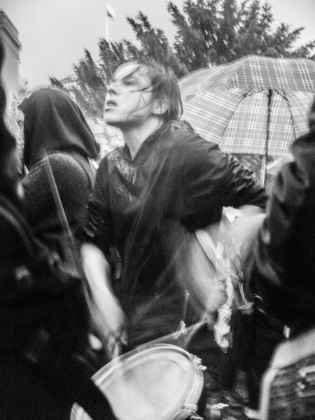 Black and white photo of a woman playing a drum at the Black Protests in Poland