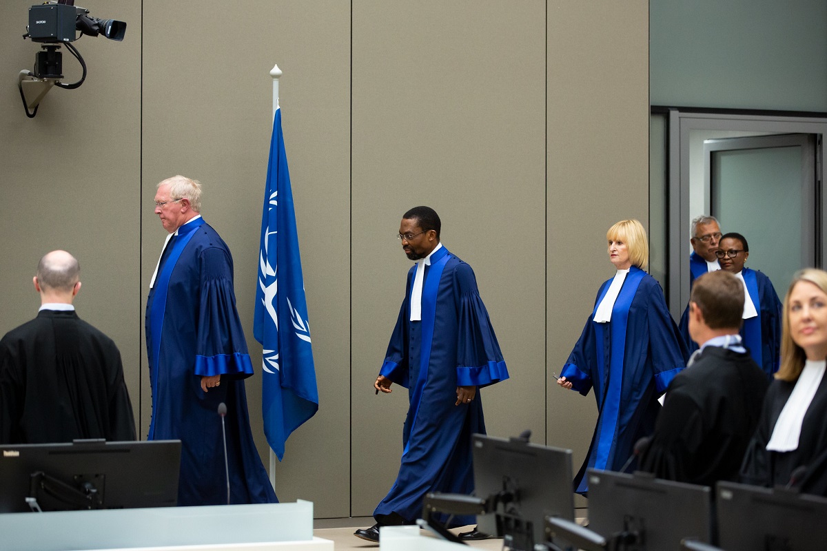 Judge Howard Morrison leads four more judges dressed in long blue robes into a courtroom at the ICC