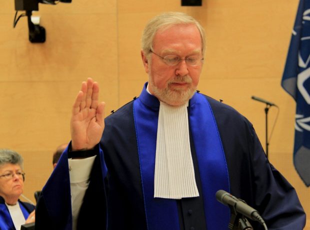 Judge Howard Morrison stands with his right hand raised as he is sworn in at the ICC