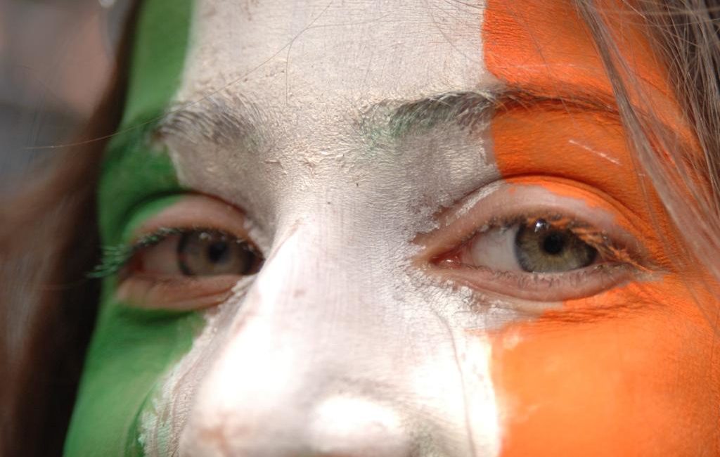 A close-up of Nour, with her face painted in the tricolour Irish flag at a St Patrick's Day parade.
