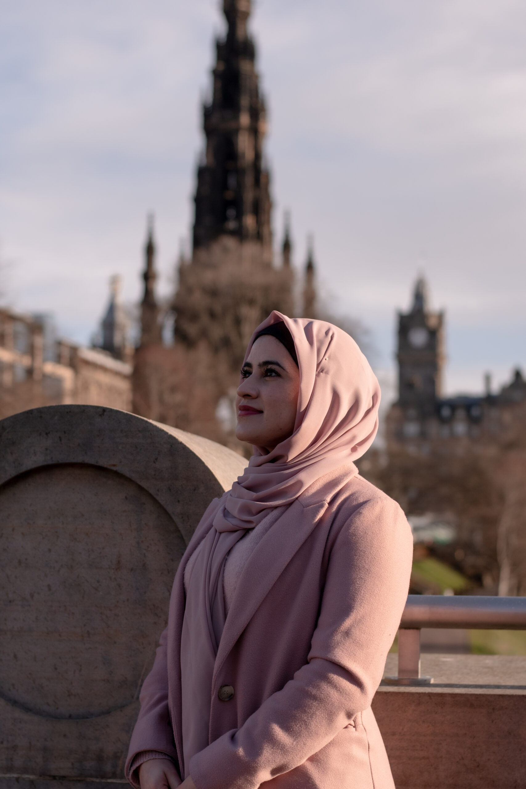 Photo of Kainat Riaz in Edinburgh in a pink coat and pink head scarf