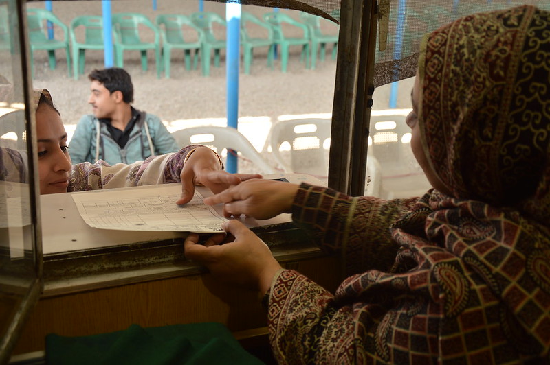 An Afghan refugee in Pakistan hands over her Proof of Registration card - European Union/ECHO/Pierre Prakash