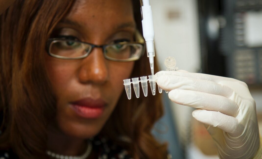 Chanelle Case Borden, Ph.D., a postdoctoral fellow in the National Cancer Institute's Experimental Immunology Branch, pipetting DNA samples into a tube for polymerase chain reaction, or PCR, a laboratory technique used to make multiple copies of a segment of DNA.
