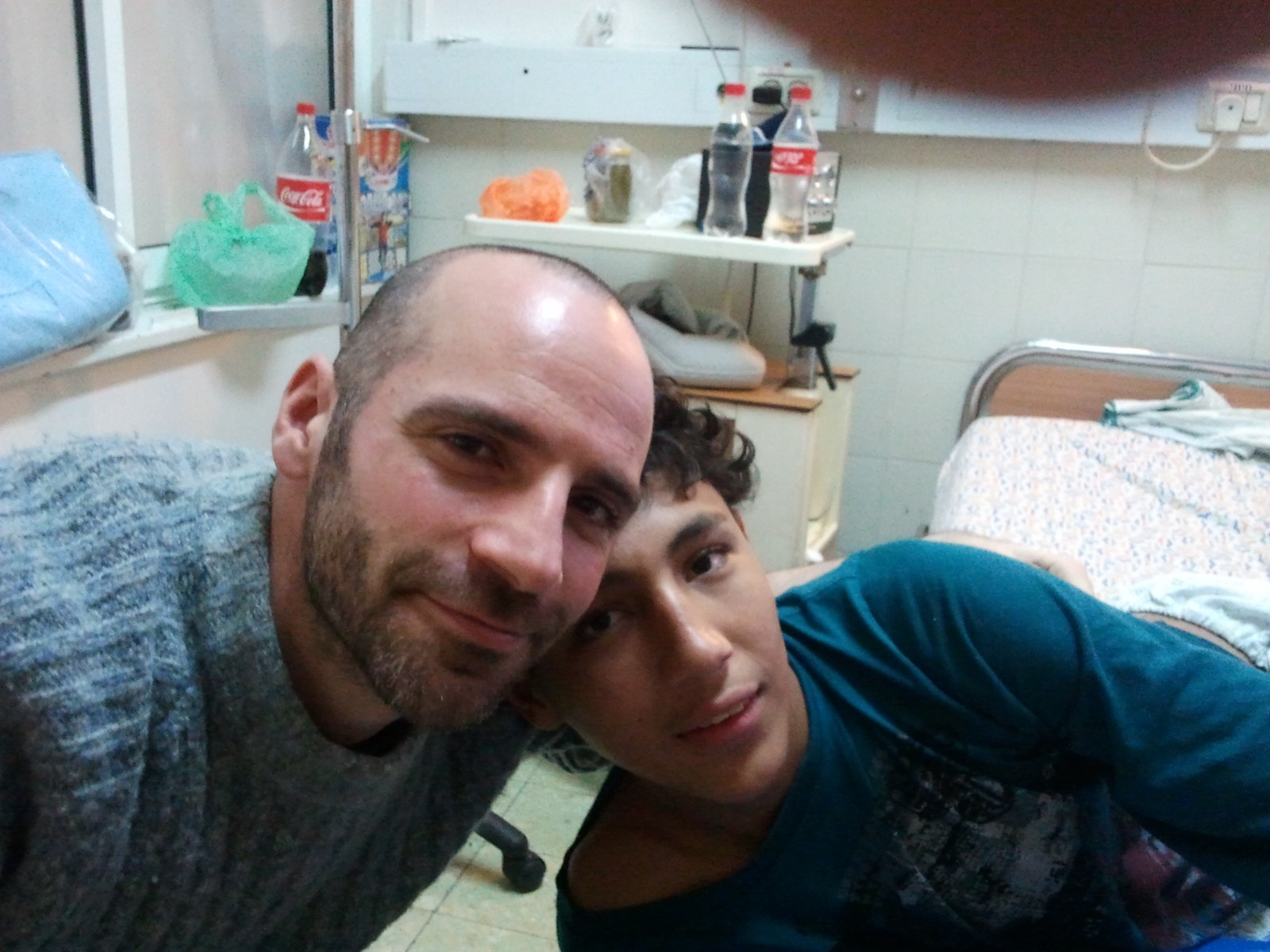 Ronnie Barkan takes a selfie with Mohammed Al Zaza while he is in hospital. They are both smiling and leaning toward each other.