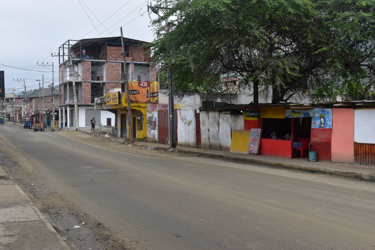 dusty street in Guayaquil lined with scaffolded buildings and colourful shacks