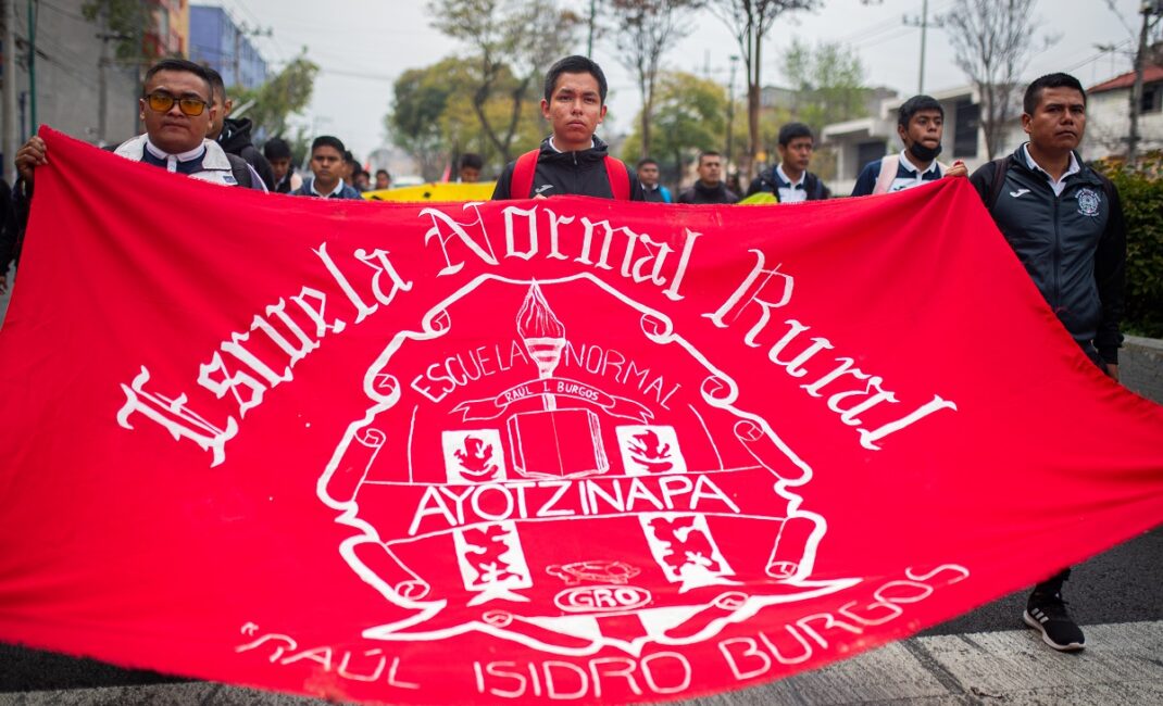 Students from Isidro Burgos school hold a large red banner at the protest