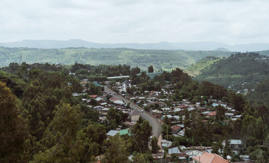  Photograph by Jaclynn Ashly showing a view of the city of Gonda, Ethiopia: city on a hilltop surrounded by trees and green