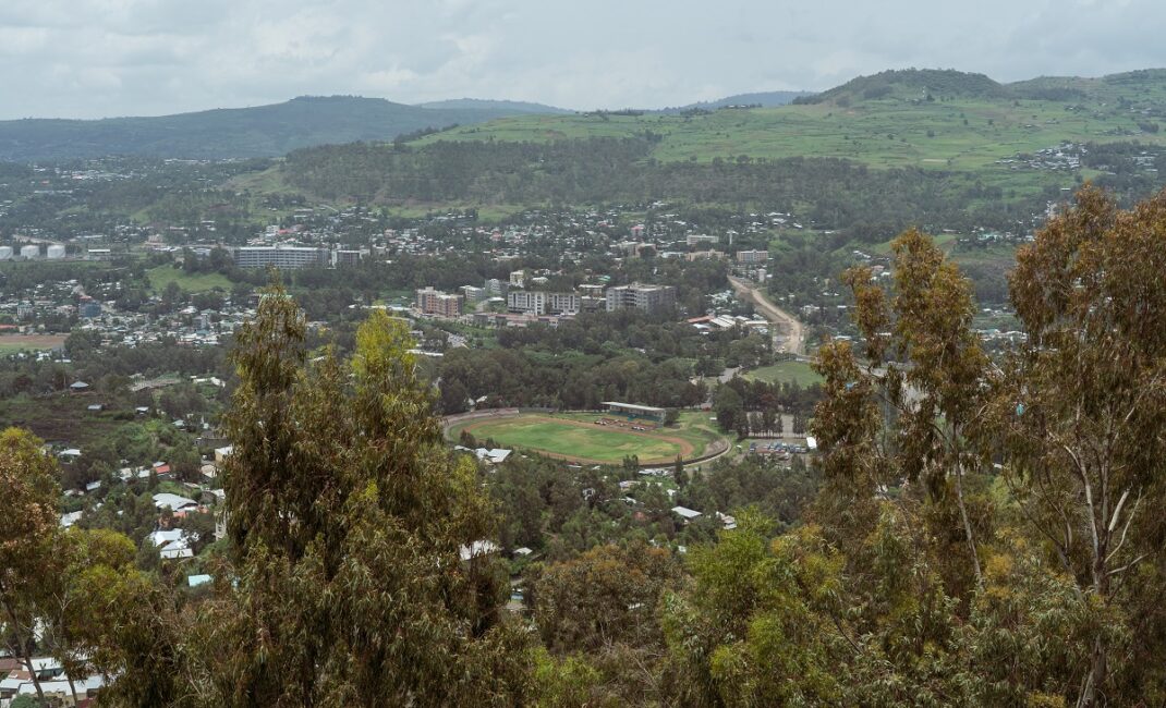  Photograph by Jaclynn Ashly showing the city of Gondar's stadium, surrounded by trees and apartment blocks.